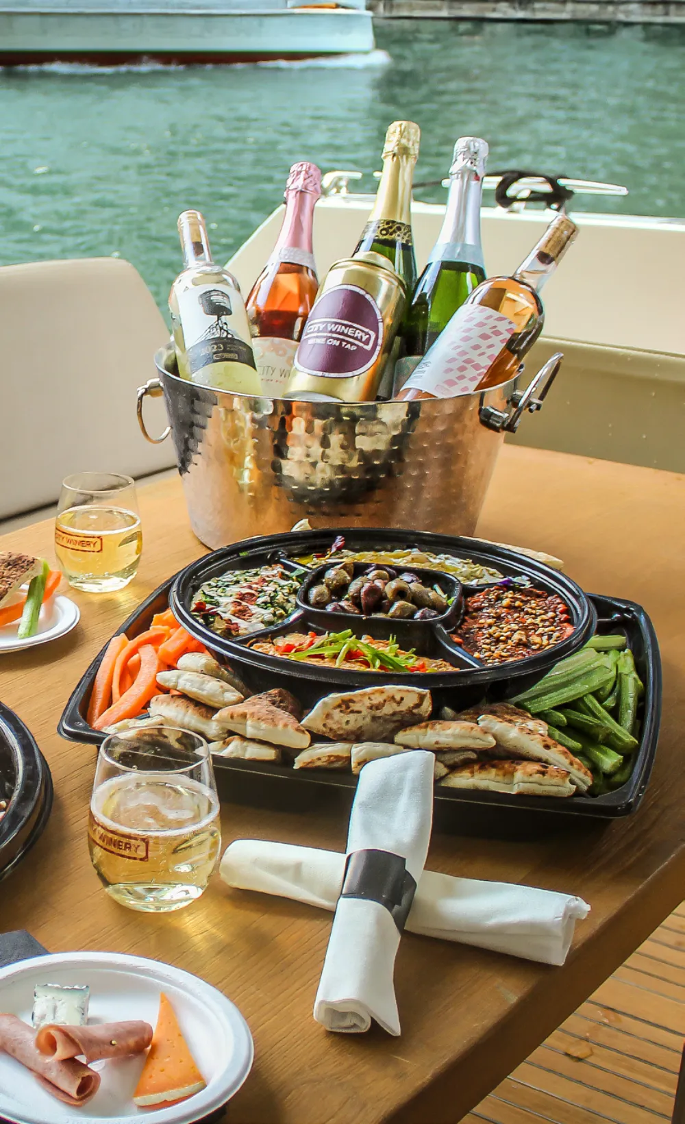 City Winery Riverwalk shareable platters and champagne on a boat docked at the Riverwalk