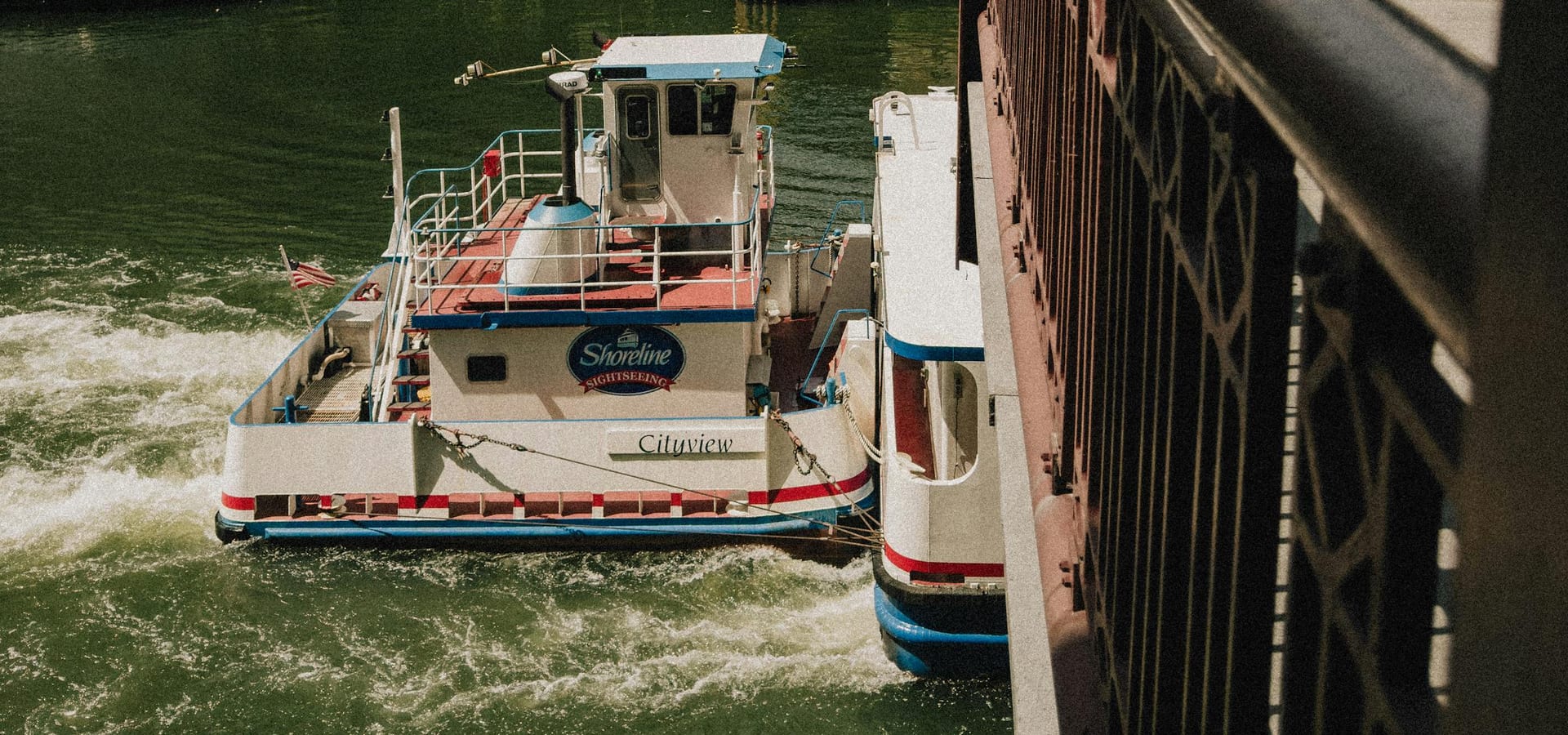Tour boat navigating the Chicago River near downtown bridges
