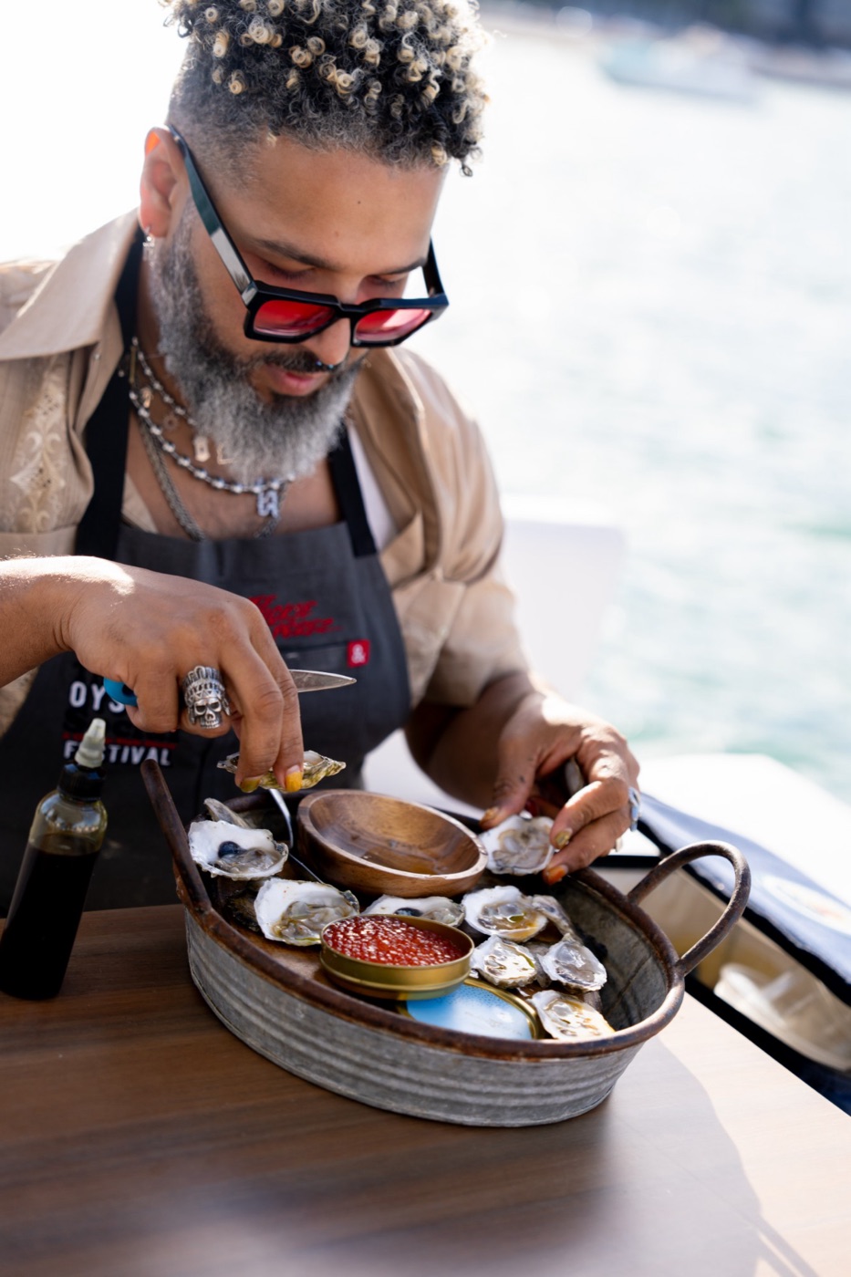 A chef preparing a fresh oyster and caviar service aboard a charter